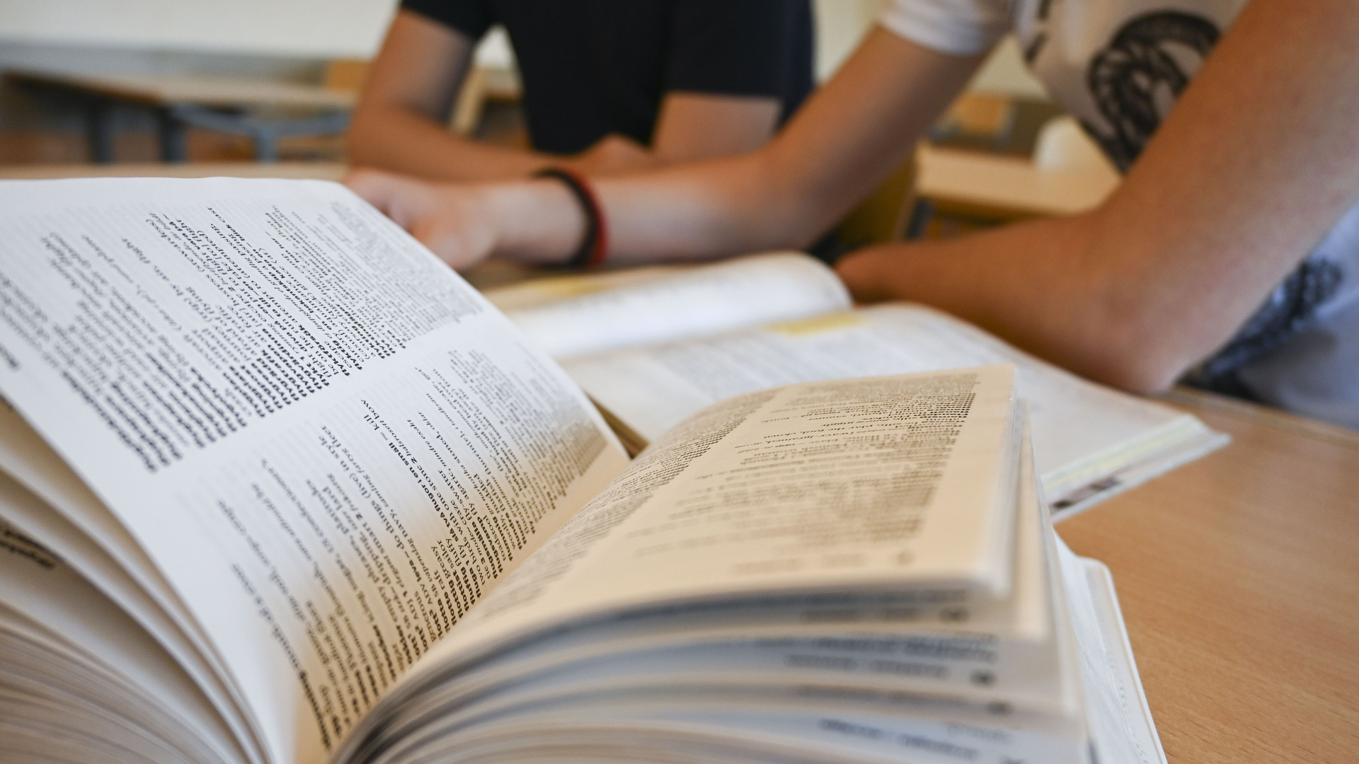 Uppslagen bok på bänk i klassrum