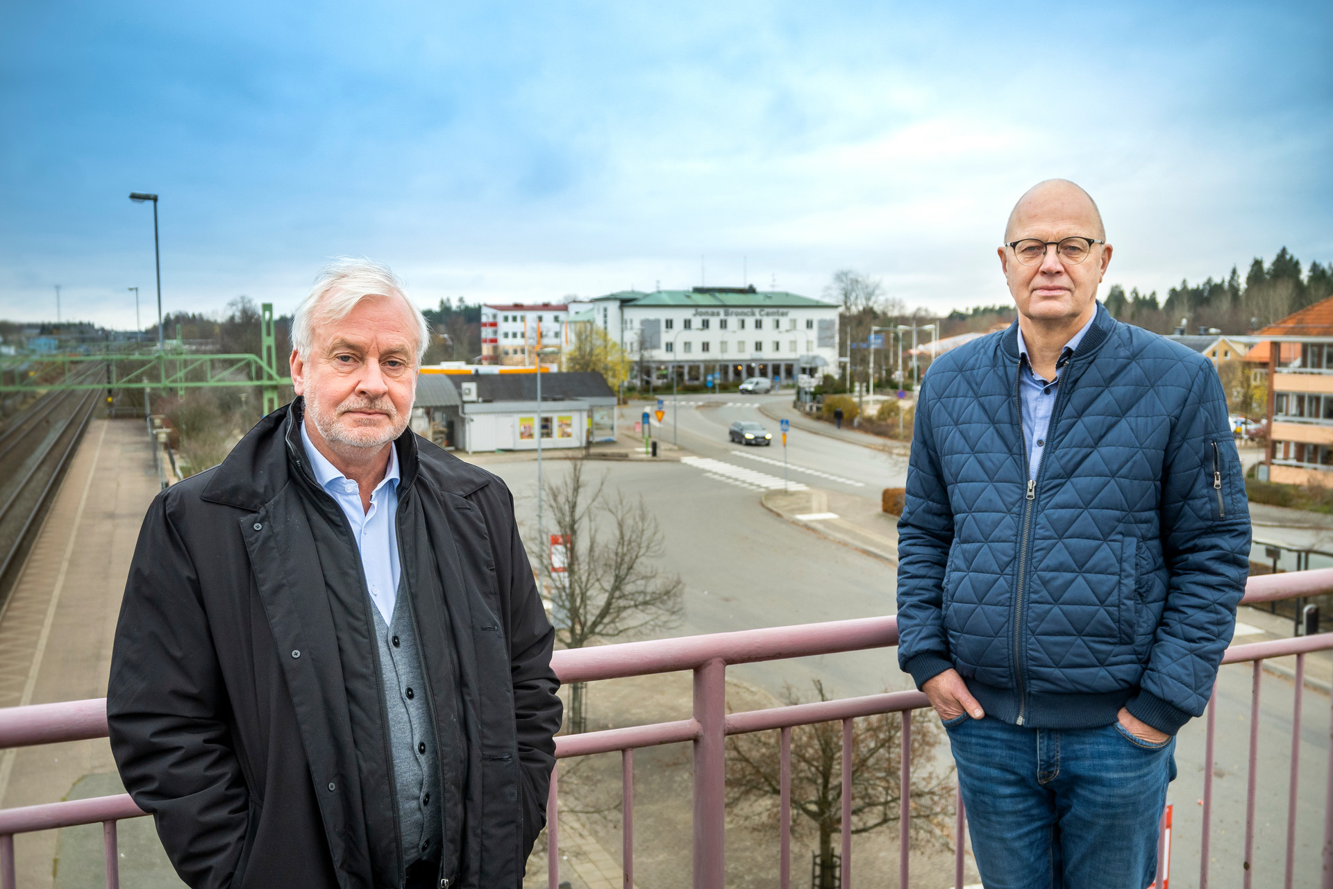 Jan Holmqvist och Stefan Gustafsson på gångbron över järnvägen med centrum i bakgrunden.