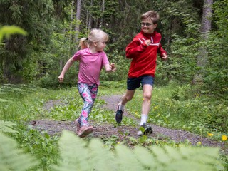 Flicka och pojke jobbar på elljusspår i skogen.