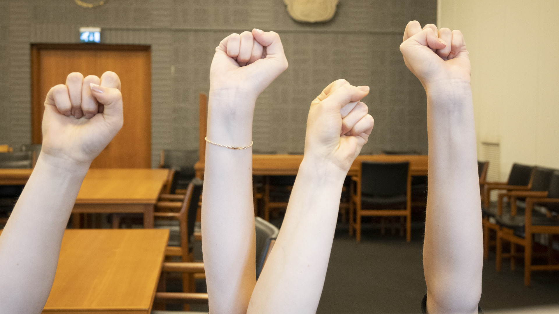 Fyra knutna händer i luften.