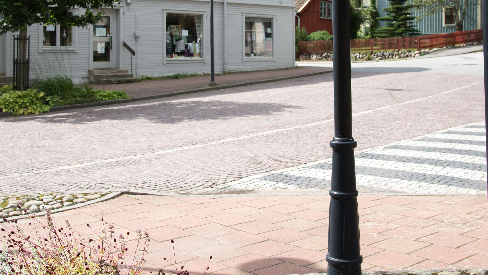 gatukorsning med övergångsställe längst bort finns ett hus