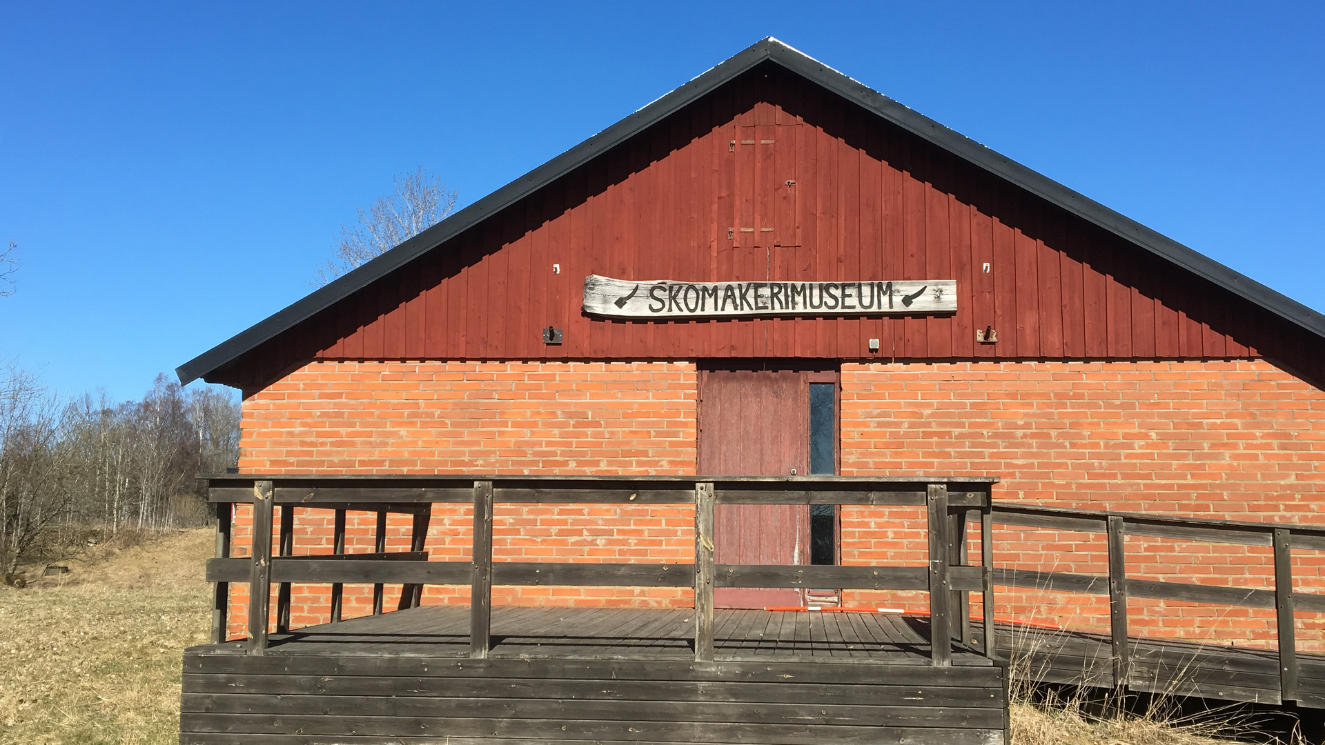 En byggnad med en skylt där det står skomakarmuseum