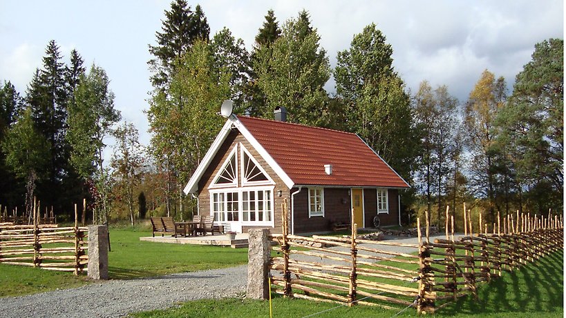 Framsidan av stugan med uteplats